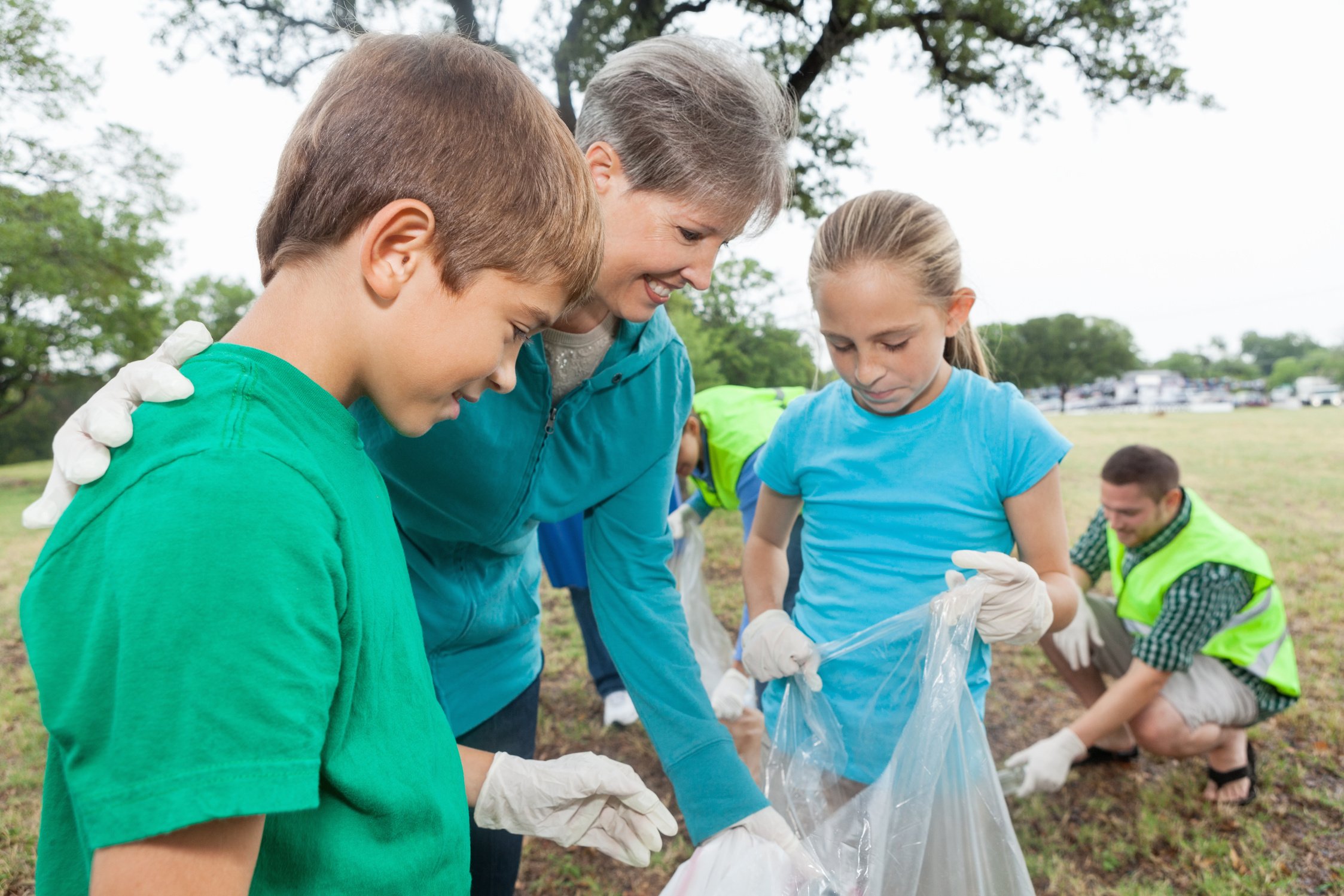 Children doing community service project with grandmother at park